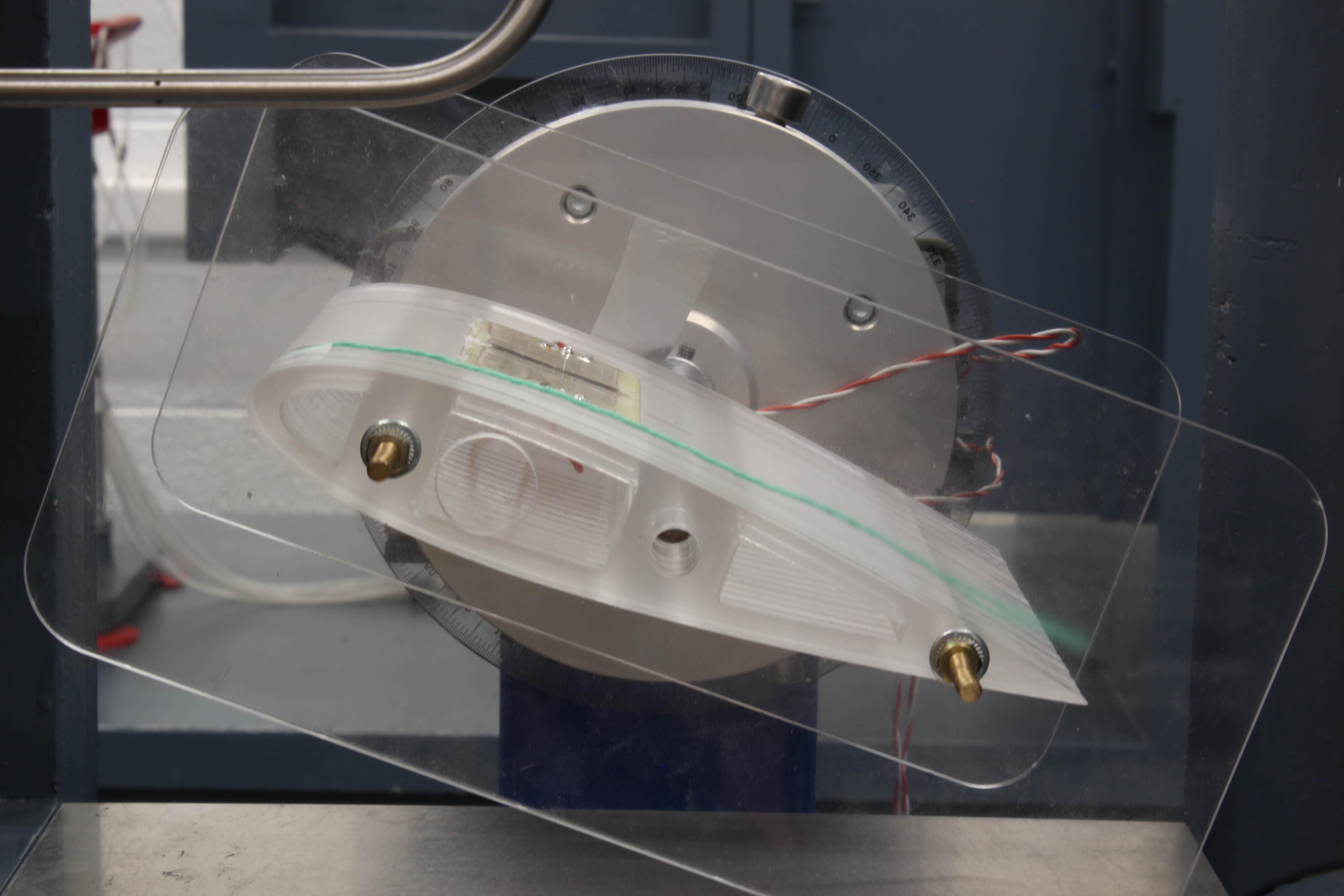 (a) NACA 0015 airfoil at low angle of attack, with the wool thread (in green) showing attached flow state.